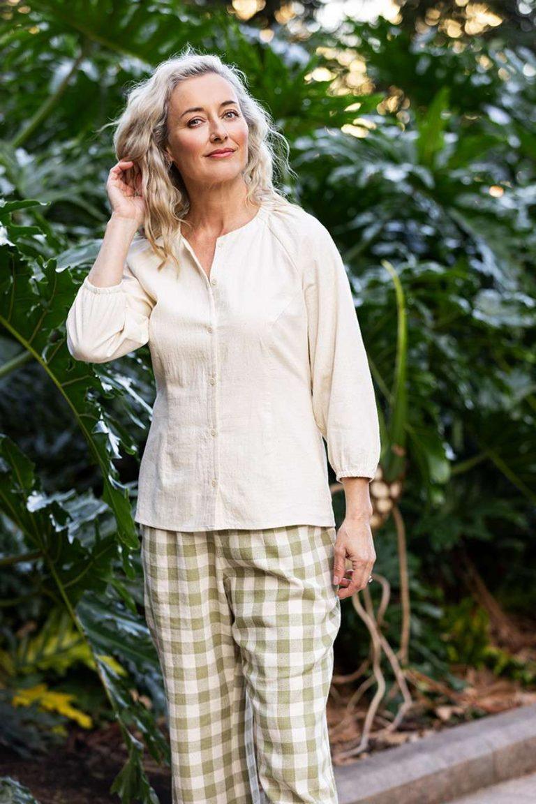Cream-colored blouse with long sleeves, paired with relaxed-fit green gingham wide-leg pants,emphasizing Colouron Cotton's slow fashion values.
