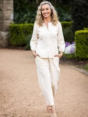 Full cream-colored set featuring a button-up blouse with three-quarter sleeves and matching wide-leg pants, embodying a timeless casual look