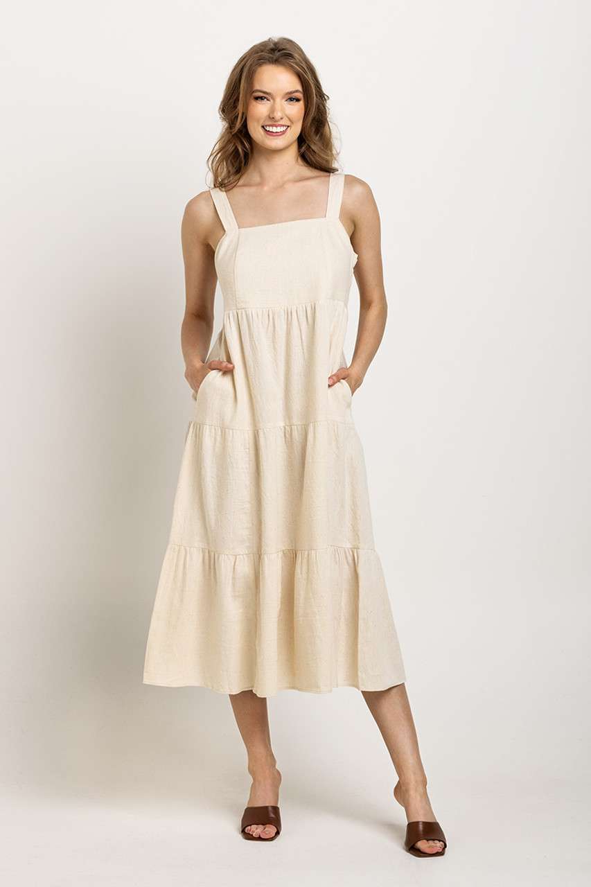 Cream, tiered midi dress with wide straps and pockets, perfect for an easy-going, sustainable wardrobe staple.