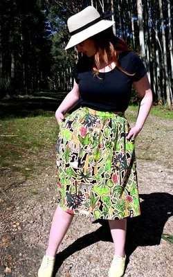 This skirt showcases a complex pattern with elements of flora, including leaves, flowers, and abstract natural shapes in shades of green, red, and yellow. The design appears dense and rich, resembling an intricate forest scene. Designed by Australian designer brand Streborclothing.