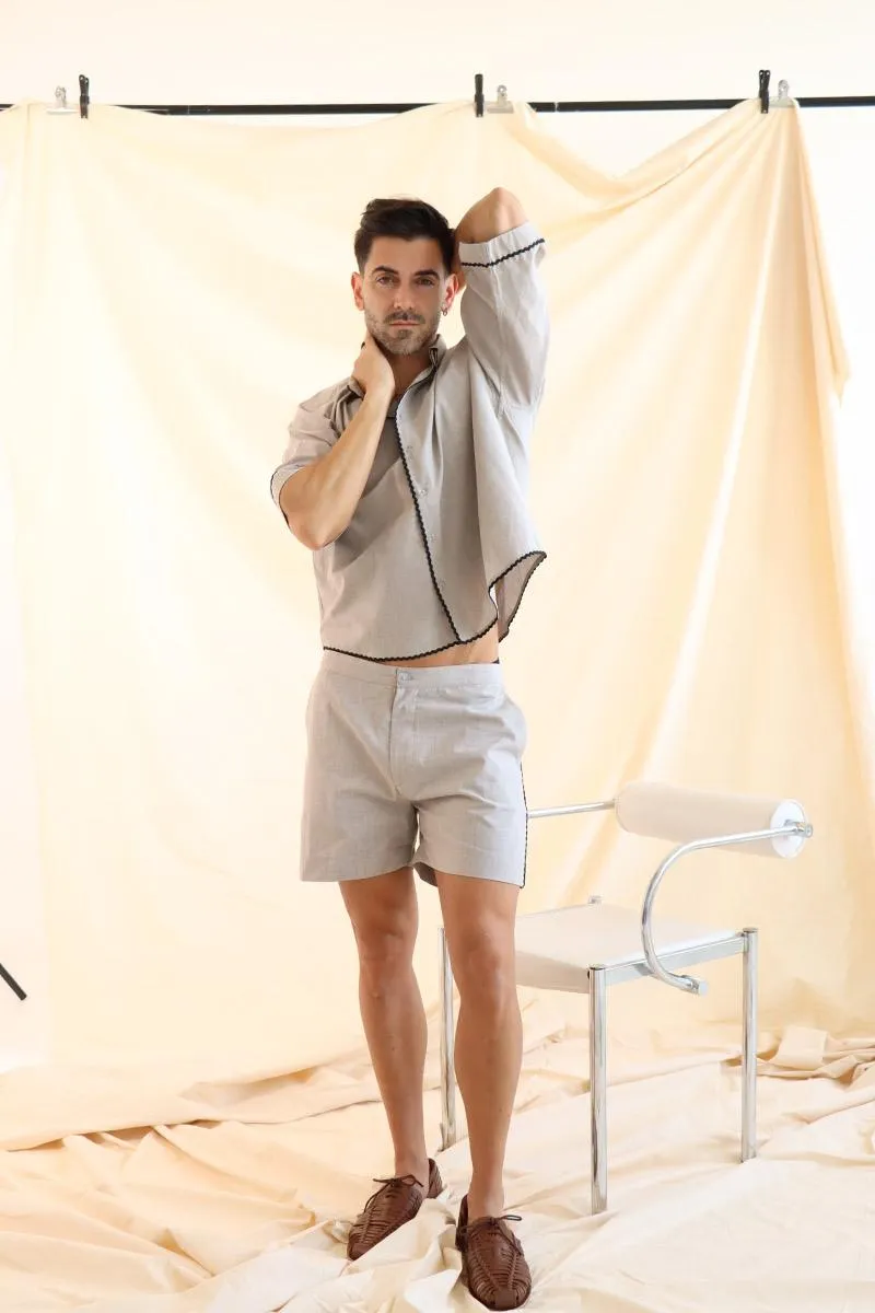 the shirt is inspired by 70s in a boxy silhouette with a button down shirt collar, button up front and drop shoulder sleeves. It is paired perfectly with short shorts, with side pockets and contrast trim on the side.